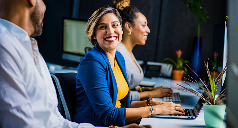 happy workers in office at computers